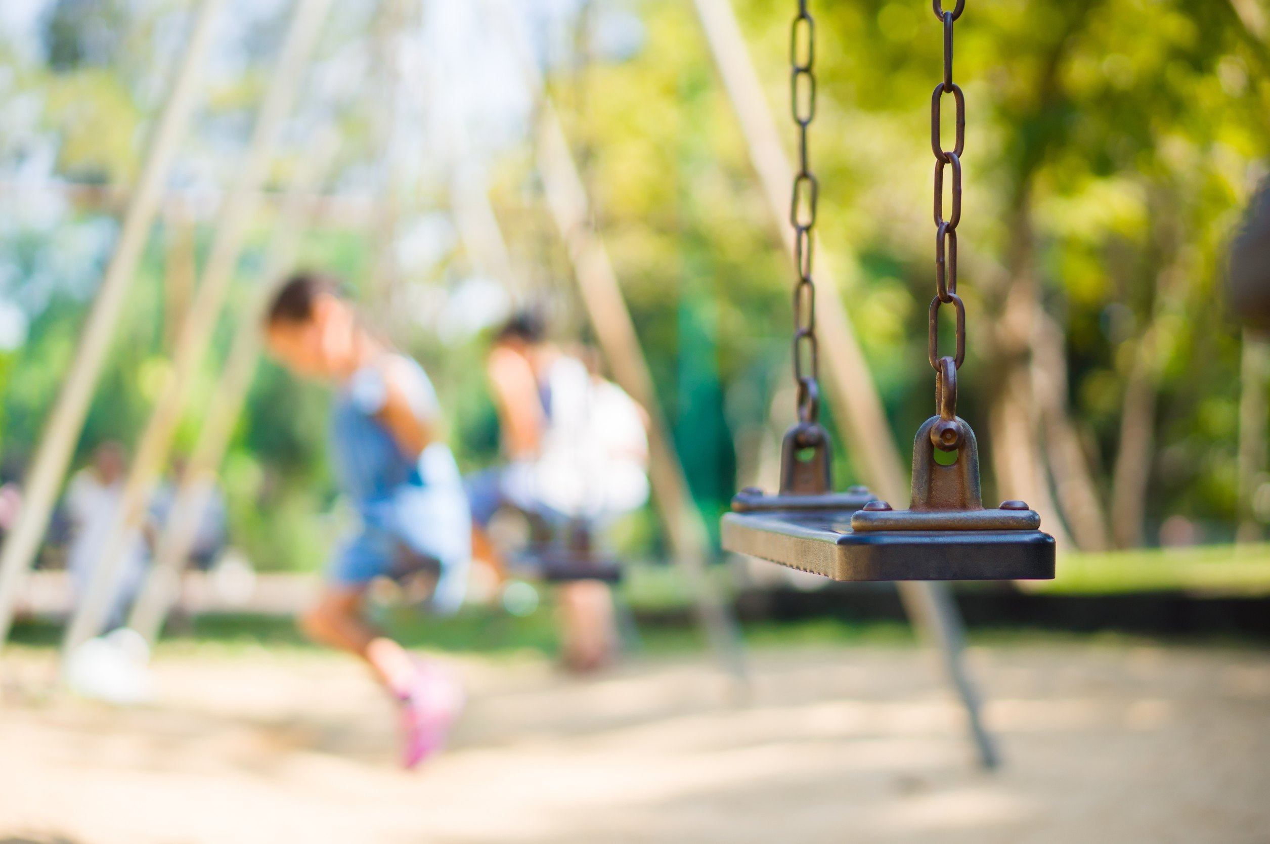 Set of chain swings on modern kids playground, kids swinging on back